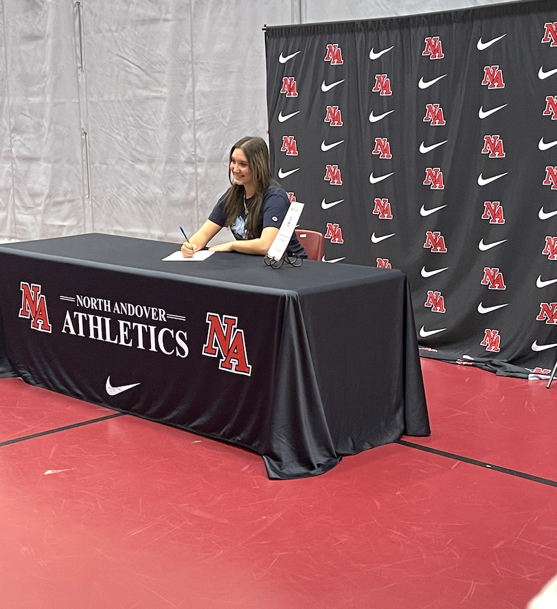 Screenshot 2025-10-05 at 3.46.03 PM girl sitting at table posing for a picture, smiling